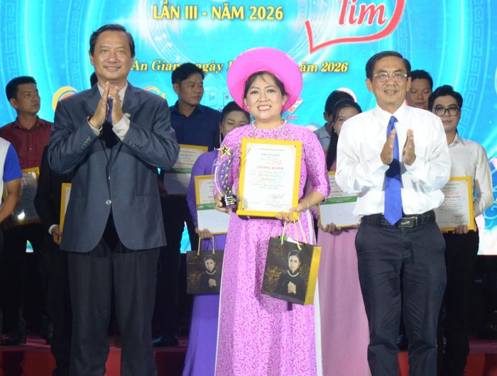Giám đốc Báo và phát thanh, truyền hình An Giang, Trưởng Ban tổ chức cuộc thi Lê Văn Chuyển (bìa trái); Phó Bí thư Đảng ủy Các cơ quan Đảng tỉnh An Giang Trần Chí Viễn (bìa phải) trao giải nhất, cúp lưu niệm, giấy chứng nhận và phần thưởng cho thí sinh Trần Thị Cẩm Hồng.