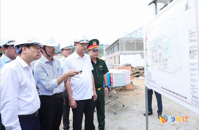 Bí thư Thành ủy Lê Ngọc Quang (thứ 2, bên phải sang), Chủ tịch UBND thành phố Nguyễn Mạnh Hùng (bên trái) nghe chủ đầu tư báo cáo tiến độ thi công Trường Phổ thông nội trú liên cấp Tiểu học - THCS Đắc Pring. Ảnh: NGỌC PHÚ