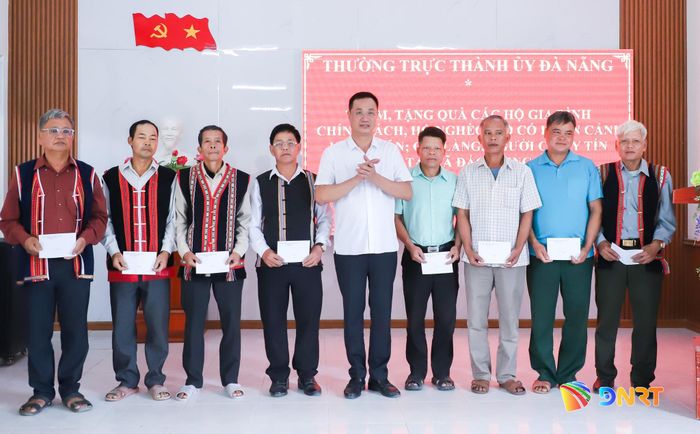 Bí thư Thành ủy Lê Ngọc Quang (thứ 5, bên phải sang) trao quà cho già làng, người có uy tín tại xã Đắc Pring. Ảnh: NGỌC PHÚ