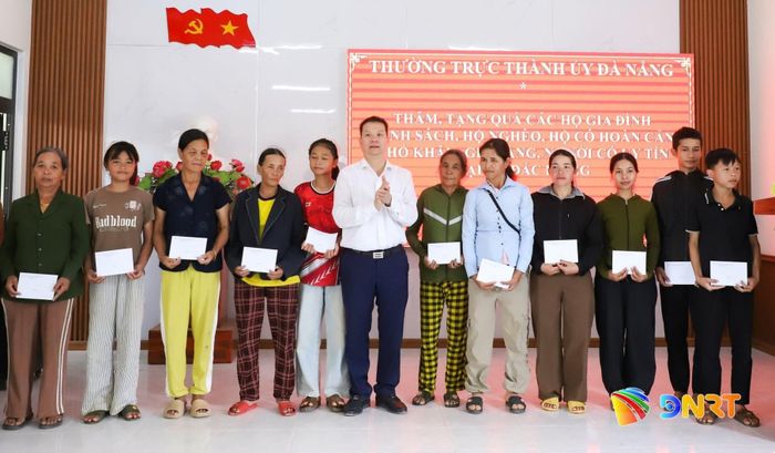 Chủ tịch UBND thành phố Nguyễn Mạnh Hùng (thứ 7, bên phải sang) trao quà cho các hộ nghèo, hộ có hoàn cảnh khó khăn tại xã Đắc Pring. Ảnh: NGỌC PHÚ