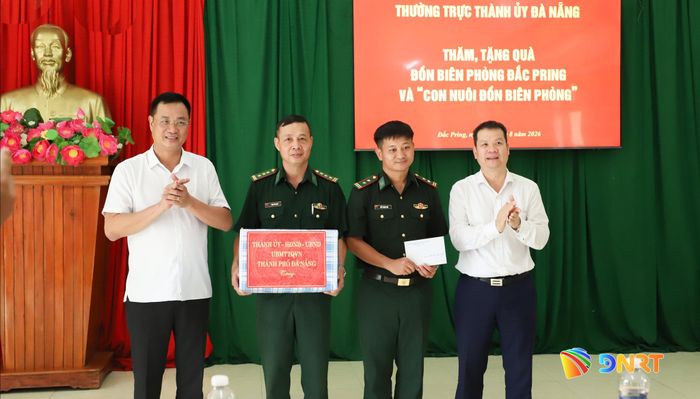 Bí thư Thành ủy Lê Ngọc Quang (bên trái), Chủ tịch UBND thành phố Nguyễn Mạnh Hùng (bên phải) tặng quà cho Đồn Biên phòng Đắc Pring. Ảnh: NGỌC PHÚ