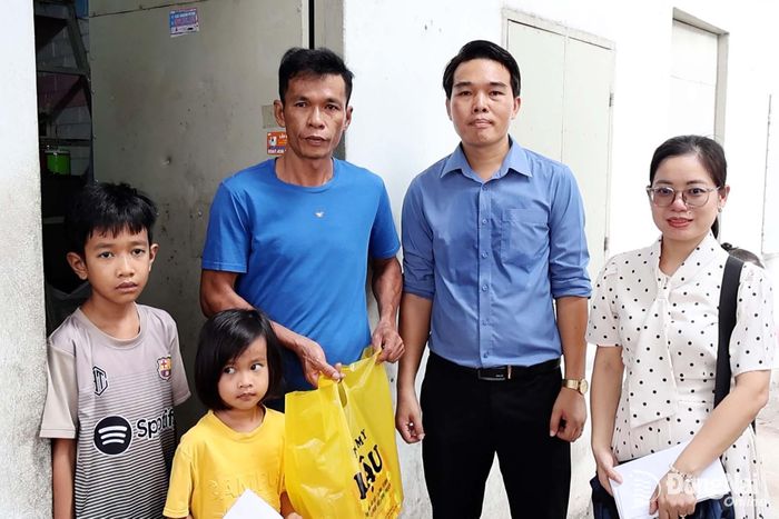 Ông Nguyễn Công Hậu (thứ 2 từ phải qua), Chủ cửa hàng điện máy Hậu trao quà cho học sinh tại khu nhà trọ. Ảnh: Viết Cường
