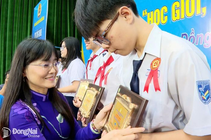Phó Chủ tịch Liên đoàn Lao động thành phố Đồng Nai Bùi Thị Bích Thủy trao khen thưởng cho các em học sinh. Ảnh: N.Hòa
