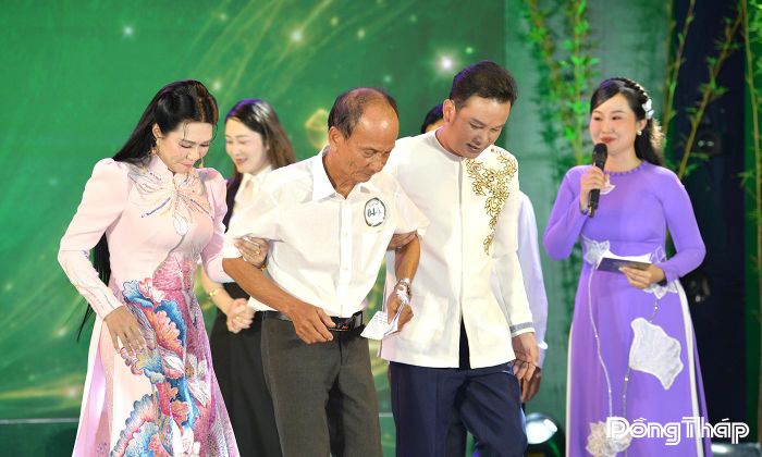 NSƯT Ngọc Huyền và NSND Hữu Quốc tận tình dìu thí sinh lớn tuổi xuống sân khấu, một khoảnh khắc đẹp tại chương trình.