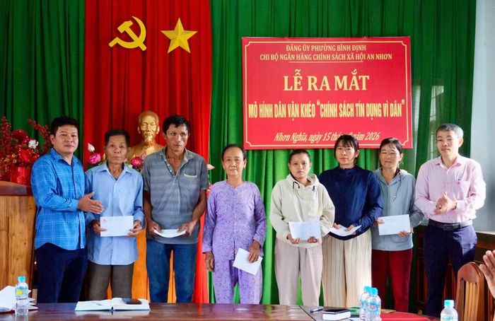  Đại diện Ngân hàng CSXH An Nhơn trao quà cho hộ cận nghèo. Ảnh: Nguyễn Muội 