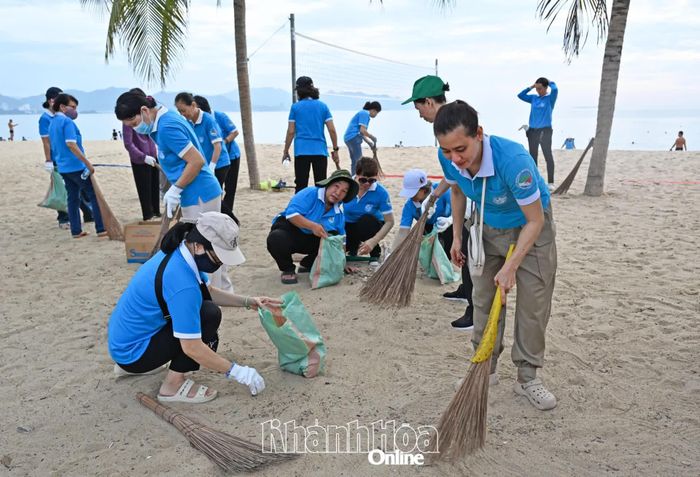 Nhiều phụ nữ tham gia thu gom rác trên bãi biển.