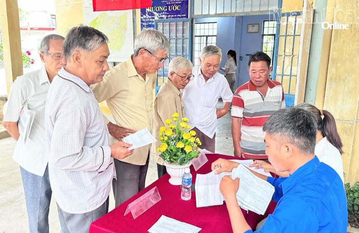 Cử tri thôn Mông Đức xuất trình giấy mời, nhận phiếu bầu cử.