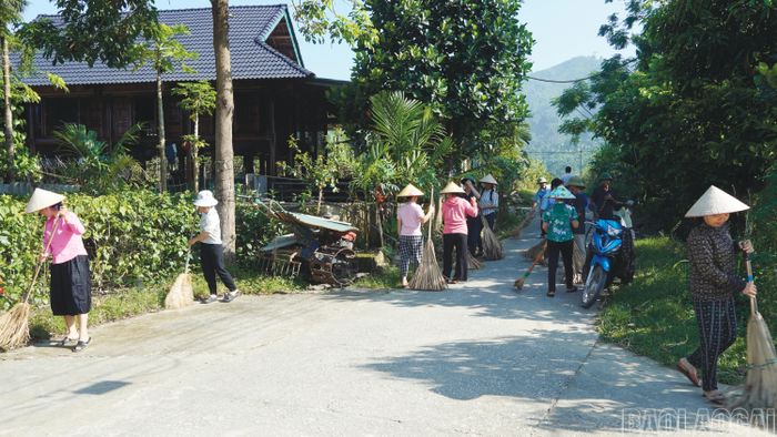 Cán bộ, đảng viên cùng người dân tham gia vệ sinh môi trường.