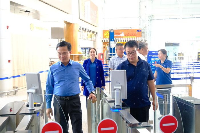 Các Phó Chủ tịch UBND tỉnh Nguyễn Ngọc Phúc và Đinh Văn Tuấn trải nghiệm "check in" nhận diện gương mặt tại Cảng hàng không quốc tế Liên Khương