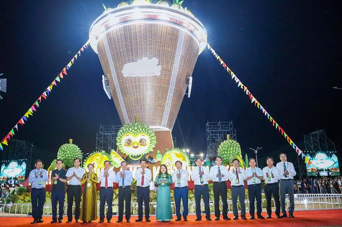 Các đại biểu chụp hình lưu niệm tại “Mô hình Chiếc gùi sầu riêng lớn nhất Việt Nam” - Ảnh: daklak.gov.vn
