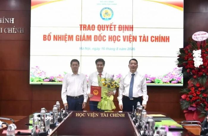 Thứ trưởng Bộ Tài chính Cao Anh Tuấn (ngoài cùng bên phải) và đồng chí Phạm Đức Thắng - Vụ trưởng Vụ Tổ chức cán bộ (Bộ Tài chính) trao Quyết định bổ nhiệm Giám đốc Học viện Tài chính cho PGS.TS Nguyễn Đào Tùng.