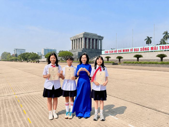 Cô Vũ Thị Ngọc Minh và học sinh lớp 7A2 Trường THCS và THPT Nguyễn Tất Thành chụp ảnh kỷ niệm sau lễ trao Học bổng Nguyễn Tất Thành lần thứ 56.
