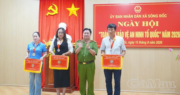  Thượng tá Nguyễn Văn Giang, Trưởng Công an xã Sông Đốc, trao cờ lưu niệm và huy chương cho các đội đạt thành tích trong các trò chơi dân gian.