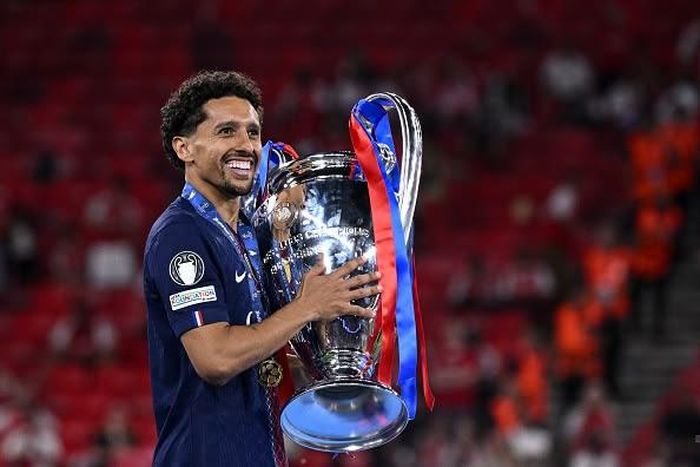 Marquinhos bên cạnh chiếc cúp C1 dành được với PSG