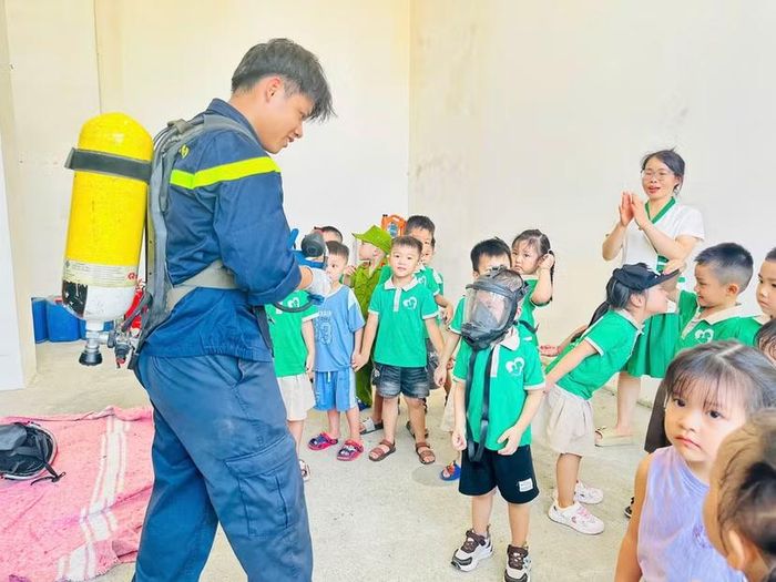 Các em nhỏ trải nghiệm trang thiết bị bảo hộ, mặt nạ phòng độc và thiết bị phục vụ công tác chữa cháy, cứu nạn, cứu hộ.