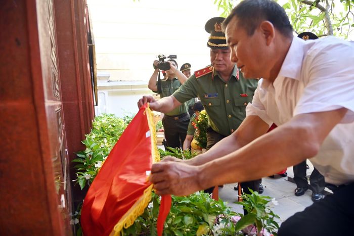 Đồng chí Giám đốc CATP cùng đại diện gia đình liệt sỹ Nguyễn Quốc Sinh thực hiện nghi lễ gắn biển tên liệt sỹ lên Đài tưởng nhiệm các anh hùng, liệt sỹ Công an Thủ đô