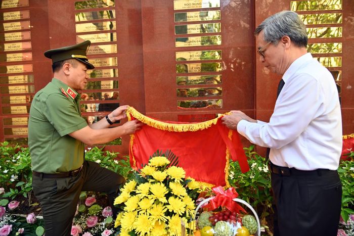Đồng chí Giám đốc CATP cùng đại diện gia đình liệt sỹ Nguyễn Quang Thụ thực hiện nghi lễ gắn biển tên liệt sỹ lên Đài tưởng nhiệm các anh hùng, liệt sỹ Công an Thủ đô