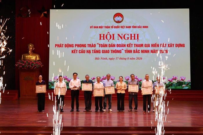 Bà Ngụy Thị Tuyến, Phó Chủ tịch Thường trực Uỷ ban MTTQ tỉnh và ông Nguyễn Nhân Chinh, Phó Chủ tịch Ủy ban MTTQ tỉnh trao bằng khen cho các cá nhân tiêu biểu hiến đất xây dựng kết cấu hạ tầng giao thông. Ảnh: Thái Nhung