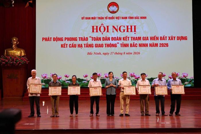 Chủ tịch Ủy ban MTTQ tỉnh Bắc Ninh Nguyễn Thị Hà tặng Bằng khen cho các cá nhân tiêu biểu hiến đất xây dựng kết cấu hạ tầng giao thông. Ảnh: Thái Nhung