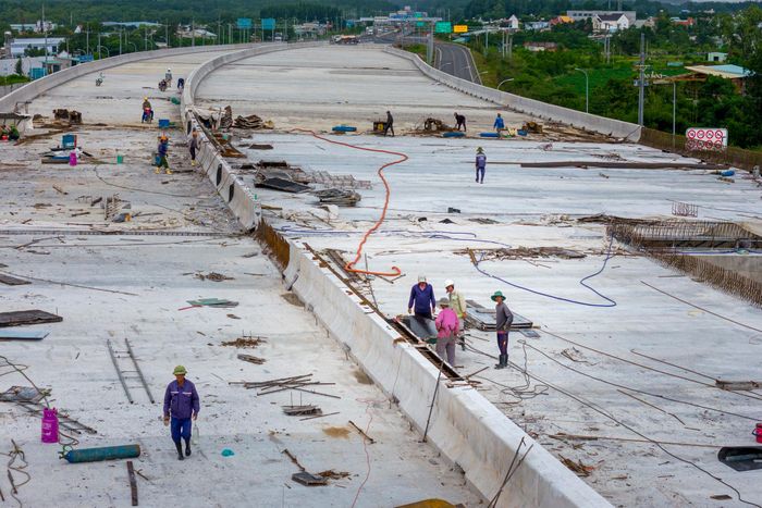  Phía trên mặt cầu, hàng chục công nhân đang thi công các hạng mục dải phân cách, khe co giãn và vệ sinh mặt cầu, sẵn sàng cho giai đoạn thảm bê tông nhựa nóng trong thời gian sắp tới. 