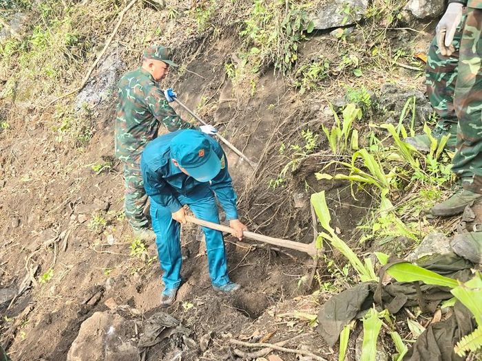 Đội tìm kiếm, quy tập hài cốt liệt sĩ và lực lượng dân quân kiên trì đào bới các hang, hốc, vách đá trên triền núi cheo leo