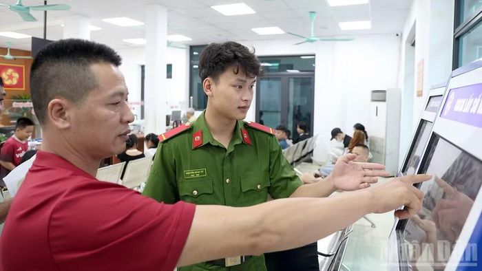 Chiến sĩ tại Bộ phận tiếp nhận và trả kết quả tập trung, Công an tỉnh hướng dẫn người dân lấy số thứ tự để thực hiện thủ tục hành chính.