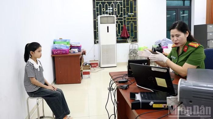 Cán bộ tại Bộ phận tiếp nhận và trả kết quả tập trung, Công an tỉnh tận tình hướng dẫn con gái anh Trần Quốc Hoàng, xã Lực Hành thực hiện thủ tục cấp căn cước.