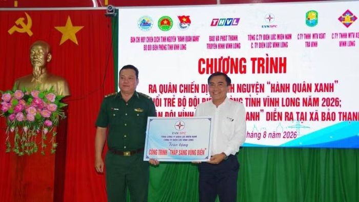Đại diện đơn vị tài trợ trao bảng tượng trưng tặng công trình "Thắp sáng vùng biên". (Ảnh: TRẦN GIỎI)