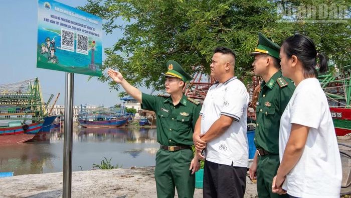 Cán bộ, chiến sĩ Bộ đội Biên phòng thành phố Hải Phòng thông tin và hướng dẫn ngư dân sử dụng mã “QR kép”.