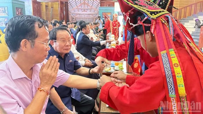 Các đại biểu hào hứng trải nghiệm hoạt động "buộc chỉ cổ tay" tại sự kiện. (Ảnh: TRỊNH DŨNG)