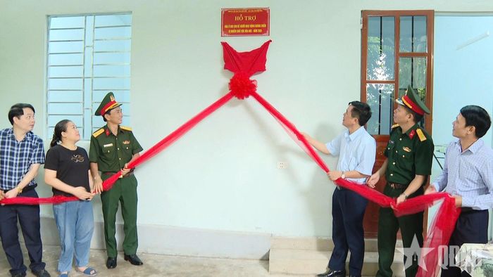  Các đại biểu và đại diện gia đình kéo băng khánh thành nhà ở.  