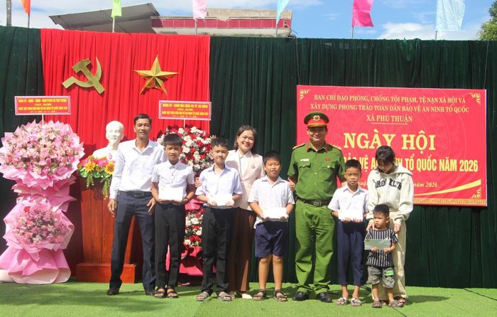 Chủ tịch UBND xã Phú Thuận Nguyễn Thị Hồng, Thượng tá Trần Minh Quang - Trưởng Công an xã Phú Thuận tặng quà cho các em học sinh có hoàn cảnh khó khăn trên địa bàn.