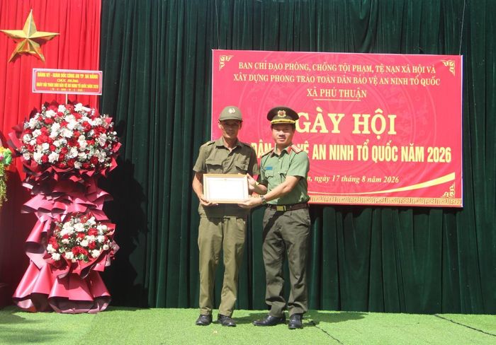 Thượng tá Nguyễn Quang Sang - Trưởng Ban Chuyên đề Công an TP Đà Nẵng trao Giấy khen của Giám đốc Công an TP Đà Nẵng tặng cho ông Phạm Văn Hùng, Tổ trưởng Tổ bảo vệ ANTT thôn Hanh Tây.