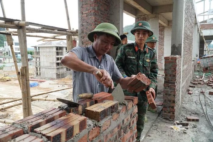 Chiến sĩ phụ giúp thợ chính trong xây dựng các dãy phòng học. Ảnh: Hồ Lài