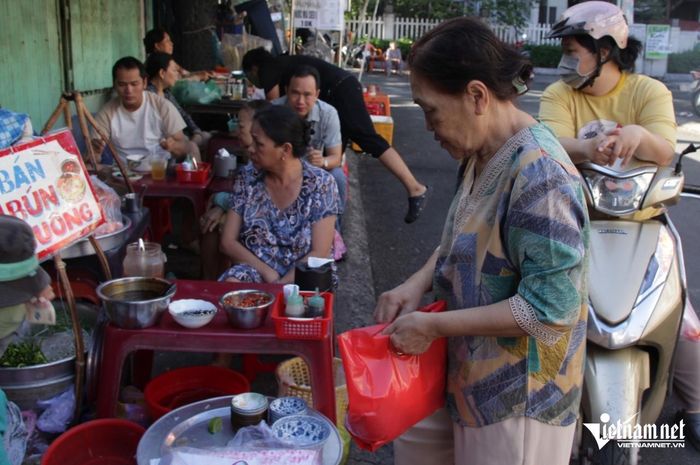 Bà Lan (tay cầm túi nilon đỏ) đã ăn bún suông tại quán từ năm 10 tuổi