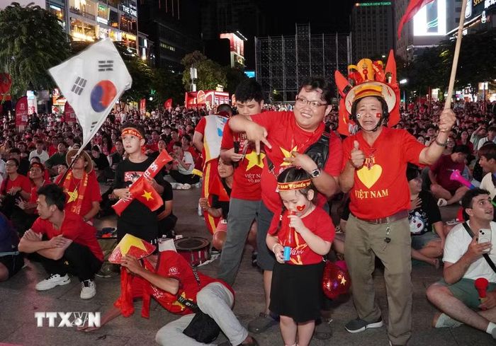 Người hâm mộ Thành phố Hồ Chí Minh cổ vũ và tiếp lửa cho đội tuyển Việt Nam qua màn hình Led tại phố đi bộ Nguyễn Huệ. (Ảnh: Trung Tuyến/TTXVN)