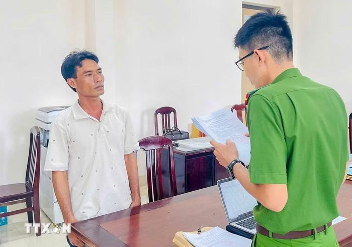 Cơ quan Cảnh sát điều tra Công an thành phố Cần Thơ tống đạt các quyết định với đối tượng Hứa Hoàng Khởi. (Ảnh: TTXVN phát)