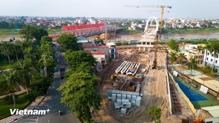 Tại hai đầu cầu thuộc phường Việt Hưng và xã Phù Đổng, mặt bằng đã được giải phóng. Máy móc, công nhân đồng loạt thi công phần đường dẫn và hạ tầng kết nối. (Ảnh: Hoài Nam/Vietnam+)