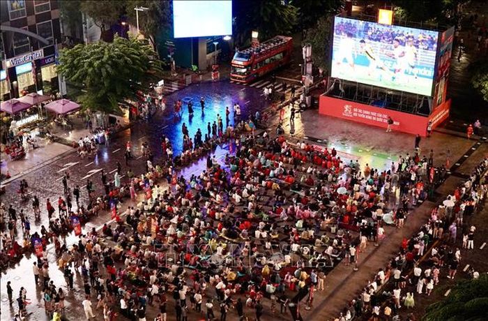 Người hâm mộ TP Hồ Chí Minh đội mưa cổ vũ cho đội tuyển Việt Nam trong những phút đầu của trận đấu bán kết lượt đi.