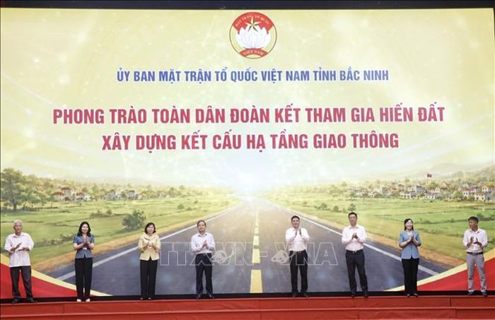 Các đại biểu thực hiện nghi thức Phát động phong trào Toàn dân đoàn kết tham gia hiến đất, xây dựng kết cấu hạ tầng giao thông.