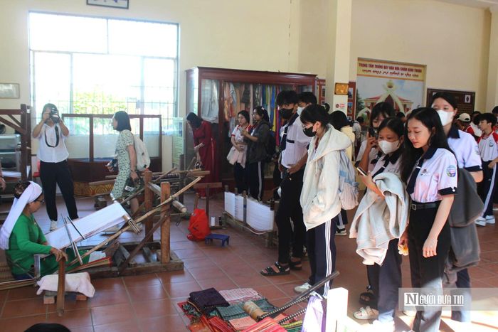 Học sinh và du khách xem các nghệ nhân biểu diễn nghề dệt truyền thống tại Trung tâm Trưng bày văn hóa Chăm.