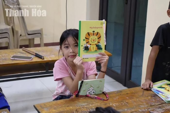 Một học sinh với cuốn vở vừa được nhận tại “Lớp học 0 đồng”.