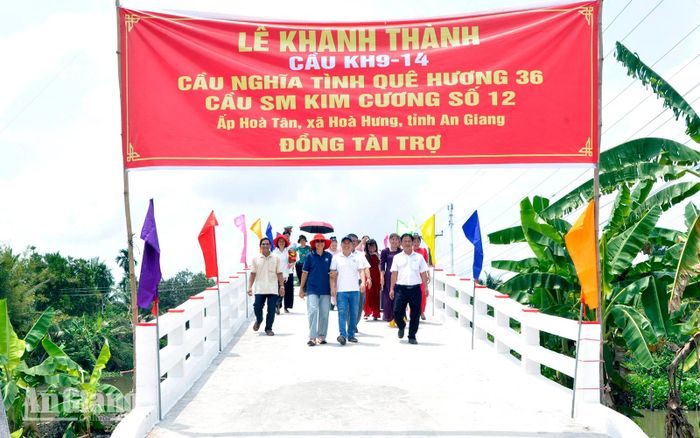 Đại biểu và người dân phấn khởi đi trên cầu KH9-14 mới được khánh thành tại ấp Hòa Tân, xã Hòa Hưng.