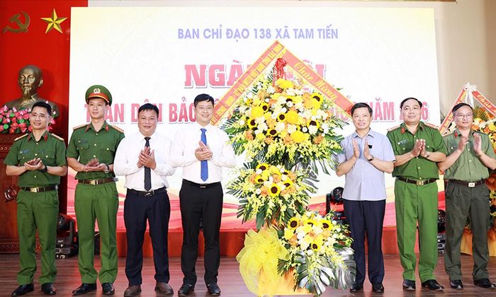  Đồng chí Đào Quang Khải và lãnh đạo Công an tỉnh tặng hoa chúc mừng Ngày hội toàn dân bảo vệ an ninh Tổ quốc xã Tam Tiến. 