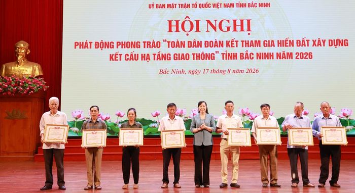 Đồng chí Nguyễn Thị Hà tặng Bằng khen cho các cá nhân tích cực tham gia hiến đất xây dựng kết cấu hạ tầng giao thông.