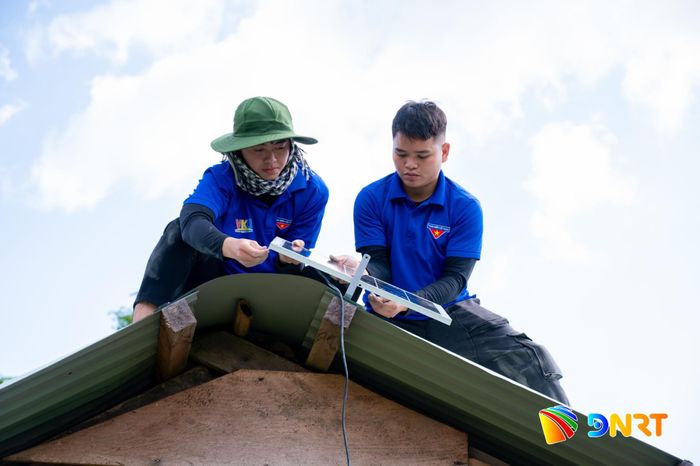 Sinh viên tình nguyện Trường ĐH Công nghệ Thông tin và Truyền thông Việt - Hàn lắp đèn năng lượng mặt trời cho người dân tại xã Trà Linh. Ảnh: ĐVCC