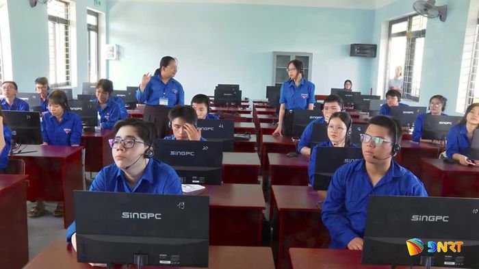 Cô giáo trẻ Lê Thị Hồng Vy Trường THPT Liên Chiểu (đeo thẻ) đang hướng dẫn, dạy kèm tiếng Anh cho học sinh có hoàn cảnh khó khăn trong lớp học mùa hè. Ảnh: T.HƯƠNG