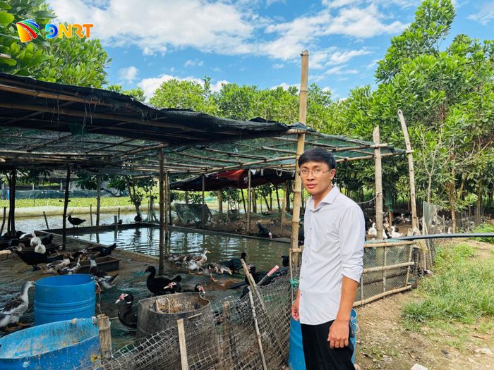 Anh Phan Văn Vương bên cạnh khu vực nuôi vịt trời của trang trại. Ảnh: H.Vũ