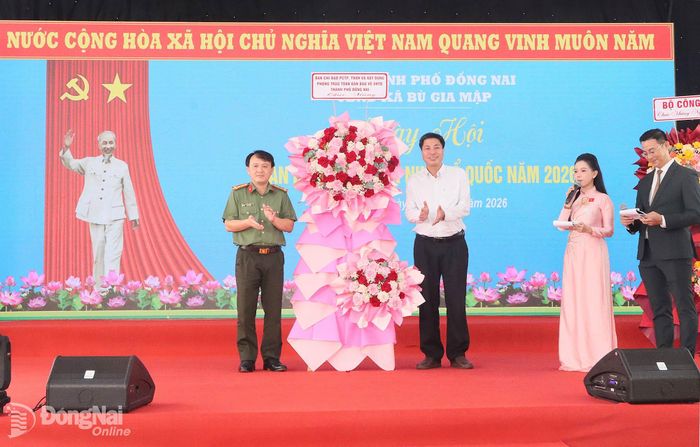 Đại tá Nguyễn Chí Toàn, Phó Giám đốc Công an thành phố, Phó Trưởng ban Chỉ đạo thành phố tặng lẵng hoa chúc mừng ngày hội. Ảnh: Quang Minh
