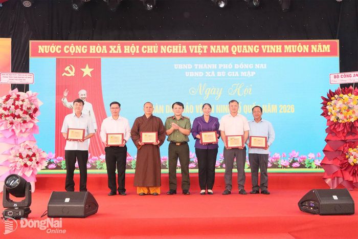 Đại tá Nguyễn Chí Toàn, Phó Giám đốc Công an thành phố, Phó Trưởng ban Chỉ đạo thành phố tặng biểu trưng cảm ơn các cơ quan, đơn vị có nhiều đóng góp trong phong trào Toàn dân bảo vệ an ninh Tổ quốc thành phố Đồng Nai. Ảnh: Quang Minh